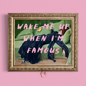 May include: A framed painting of a woman lying on a green couch with the text "Wake me up when I'm famous" written in pink.