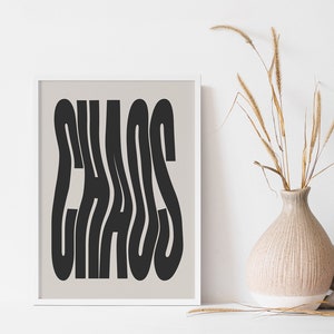 May include: A framed print with a beige background and black text that reads "CHAOS" in a stylized font.