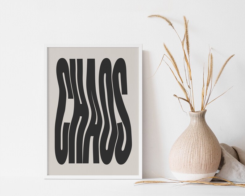 May include: A framed print with a beige background and black text that reads "CHAOS" in a stylized font.