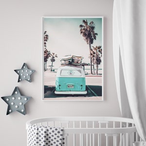 May include: A vintage teal blue van with surfboards on the roof parked in front of a beach with palm trees. The van has a license plate that says "SURFCT".