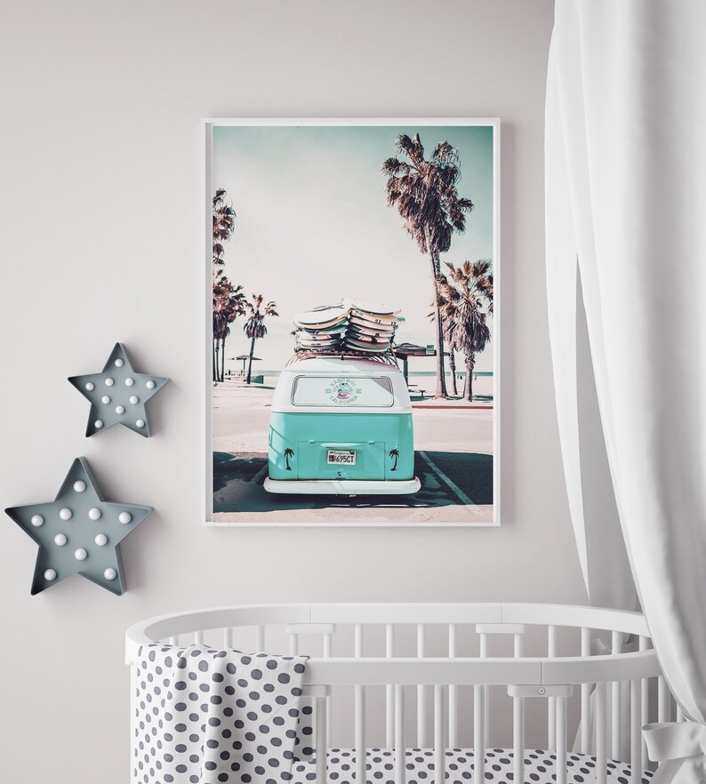 May include: A vintage teal blue van with surfboards on the roof parked in front of a beach with palm trees. The van has a license plate that says "SURFCT".