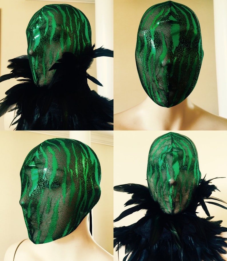 May include: Green and black masquerade mask with a zebra print pattern. The mask is made of a sheer fabric and has a black feather boa around the neck.