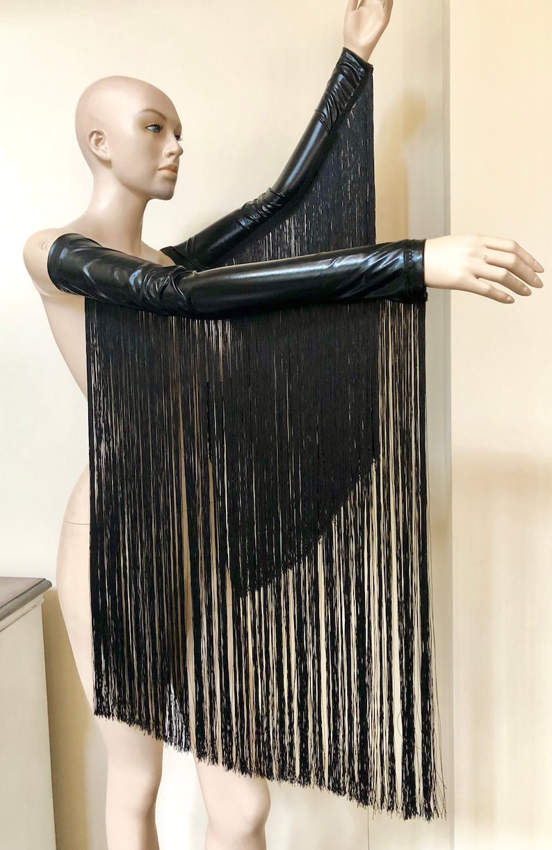 May include: A pair of black long-sleeved gloves with fringe. The gloves are made of a shiny, stretchy material.