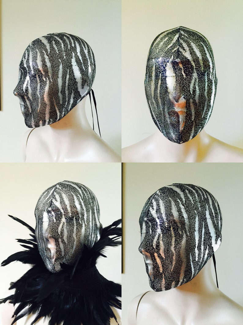 May include: A black and white zebra patterned mesh mask with a black ribbon tie. The mask is on a white mannequin head.