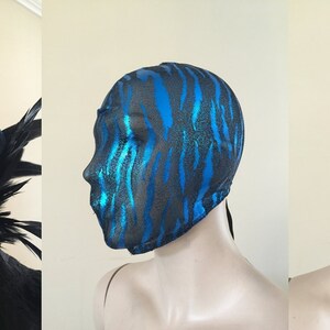 May include: A black and blue face mask with a zebra print pattern. The mask is made of a stretchy material and has a tie at the back.