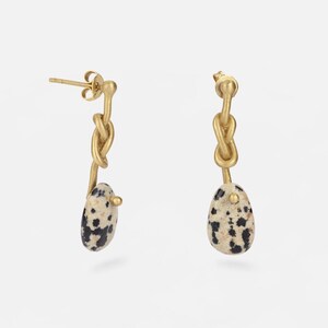 Handmade long brass 18k gold plated knot earrings with Dalmatian jasper pendants. Boho-chic artisanal jewelry, perfect for elegant and natural looks.