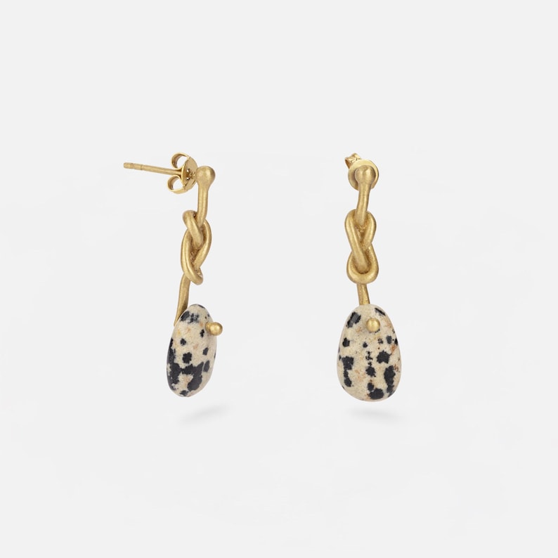 Handmade long brass 18k gold plated knot earrings with Dalmatian jasper pendants. Boho-chic artisanal jewelry, perfect for elegant and natural looks.