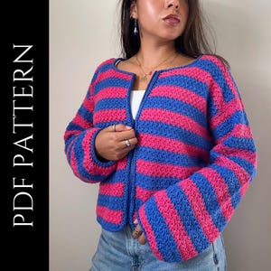 May include: A blue and pink striped crochet cardigan with a zipper closure. The cardigan features horizontal stripes and long sleeves. The text "PDF PATTERN" is printed vertically on the left side of the image.