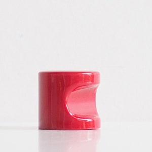 May include: A red ceramic cabinet knob with a unique, curved design.