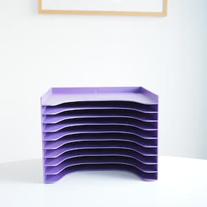 Könnte beinhalten: Ein violetter, mehrstufiger Ablageordner aus Kunststoff mit acht Fächern. Der Ordner ist für die Aufbewahrung von Papieren, Dokumenten oder anderen Büroartikeln konzipiert.