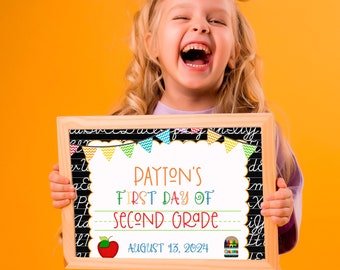 Może przedstawiać: Dziewczynka trzyma tablicę z napisem "PAYTON'S FIRST DAY OF SECOND GRADE AUGUST 13, 2024". Tablica jest ozdobiona kolorowymi flagami i rysunkiem czerwonego jabłka i kredek.