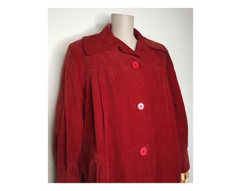 May include: A red corduroy jacket with a collared neckline and four red buttons. The jacket has a slightly oversized fit and long sleeves.