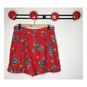 Peut inclure: Short rouge à imprimé de chien noir et blanc et pois verts.