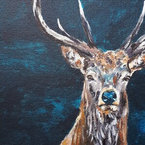 May include: A detailed painting of a stag with large antlers against a dark blue background. The stag has brown fur with white accents on its antlers and chest. The artwork is a close-up portrait.