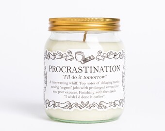 May include: A glass jar candle with a gold lid and a white label that reads "PROCRASTINATION" and "I'll do it tomorrow". The label also includes a quote about delaying tactics and the classic excuse, "I wish I'd done it earlier".