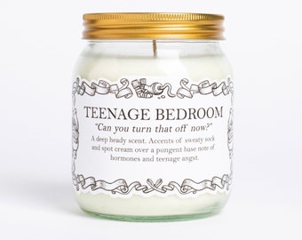 May include: A glass jar candle with a gold lid and a white label that reads "TEENAGE BEDROOM "Can you turn that off now?" A deep heady scent. Accents of sweaty sock and spot cream over a pungent base note of hormones and teenage angst."