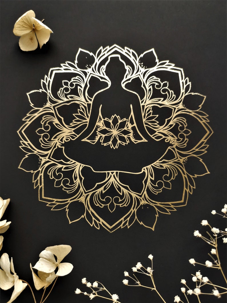 May include: A gold mandala design with a silhouette of a person sitting in a meditation pose in the center. The mandala is on a black background.
