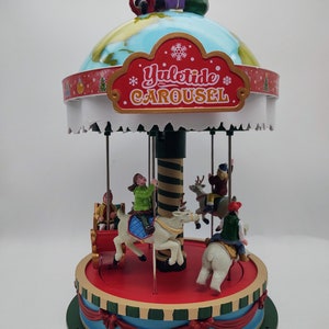May include: A red, white, and green Christmas carousel with a globe on top. The globe has a Santa Claus figure on it and a sign that says "North Pole". The carousel has a sign that says "Yuletide Carousel" and features a variety of figures, including a reindeer, a polar bear, and a horse.
