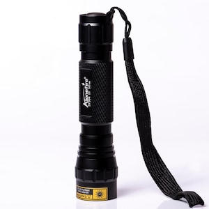 May include: A black cylindrical UV flashlight with a textured grip and a black wrist strap. The body features the white text Alonefire SV004 UV 365nm. A yellow warning label with a sun icon and text is visible on the base of the flashlight head.
