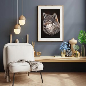 May include: A framed print of a wolf's head, with a dark background, in a living room setting with a white chair, a wooden table, and decorative items.
