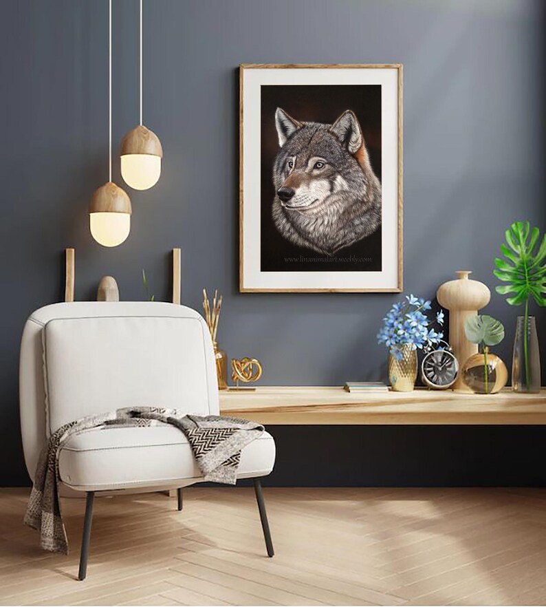 May include: A framed print of a wolf's head, with a dark background, in a living room setting with a white chair, a wooden table, and decorative items.