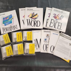 Könnte beinhalten: Eine Sammlung alter Microsoft Office Softwarehandbücher und Disketten. Das Set enthält Benutzerhandbücher für PowerPoint, Word und Excel sowie mehrere 3,5-Zoll-Disketten, die jeweils mit einem gelben Aufkleber mit der Aufschrift You're important to us. Register today! versehen sind.