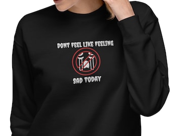May include: Black sweatshirt with a white graphic that says "Don't feel like feeling sad today" with a red circle and a crossed-out image of a drum set.