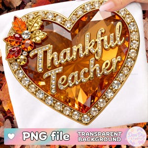 Puede incluir: Un diseño en forma de corazón con las palabras "Thankful Teacher" en letras doradas, rodeado de brillantes pedrería. El corazón es de color ámbar facetado, con un acento floral de hojas de otoño. El diseño está sobre un fondo blanco.