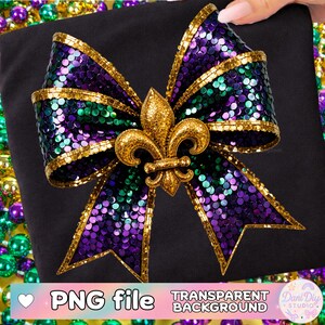 Puede incluir: Un gran lazo decorativo con lentejuelas moradas, verdes y doradas, centrado con una flor de lis dorada. El lazo está sobre un fondo negro. Las palabras "PNG file" y "Transparent Background" son visibles.