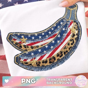 Puede incluir: Una camiseta blanca con un diseño de plátano con temática de la bandera estadounidense. El plátano está hecho de mezclilla, rayas rojas y blancas, estrellas azules y detalles de estampado de leopardo. Se incluyen adornos de estrellas doradas.