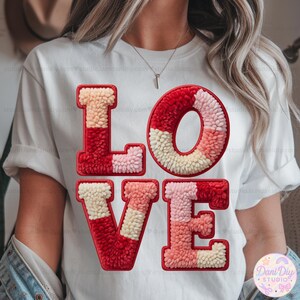 Może przedstawiać: Biała koszulka z napisem "LOVE" w teksturowanym, kolorowym wzorze. Litery są czerwone, różowe i kremowe, tworząc żywą i przyciągającą wzrok grafikę. Koszulka to codzienna, casualowa odzież.