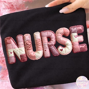 Puede incluir: Tela negra con la palabra "NURSE" aplicada en estilo patchwork. Las letras son en tonos rosas y rojos, con acentos de corazón. Las letras están delineadas con una puntada decorativa.