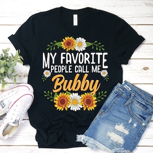 May include: Black t-shirt with a floral design and the text "My favorite people call me Bubby".