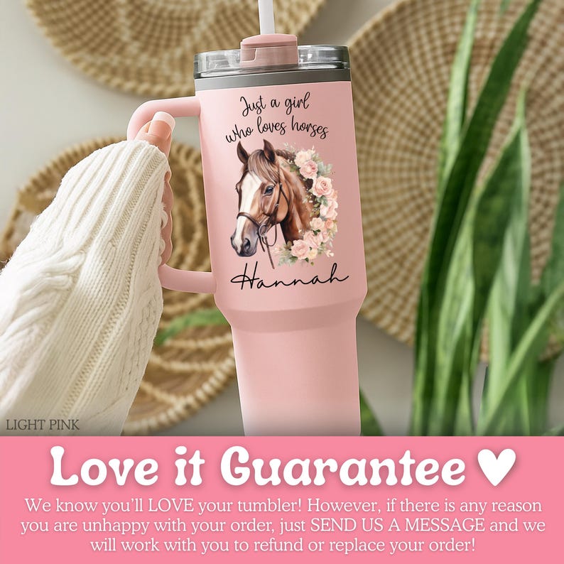 K&ouml;nnte beinhalten: Ein hellrosa Becher mit Henkel und durchsichtigem Deckel, verziert mit einer Grafik eines braunen Pferdekopfes, der von rosa Rosen umgeben ist. Der Text Just a girl who loves horses und der Name Hannah stehen in schwarzer Schreibschrift.