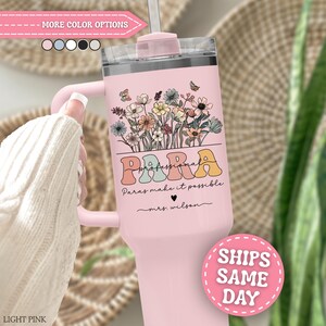 May include: A light pink tumbler with a handle and a clear lid featuring a colorful floral illustration, the text "PARA professional" in a retro font, the phrase "Paras make it possible" with a heart, and the name "mrs. wilson" printed in black.