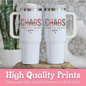 May include: Two white travel mugs with handles, each featuring the text "CHAOS coordinator" in a mix of colors. Below, it reads "PROBLEM SOLVING SUPERWOMAN" and "jessica" with a heart. The mugs are on a wooden surface.