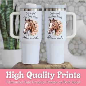 K&ouml;nnte beinhalten: Zwei wei&szlig;e Edelstahlbecher mit Henkel, verziert mit einer braunen Pferdeillustration und rosa Blumen. Der Text lautet Just a girl who loves horses und der Name Hannah. Die Becher verf&uuml;gen &uuml;ber einen transparenten Deckel.