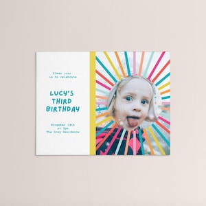 May include: A colorful birthday invitation with a photo of a young girl with her tongue sticking out. The invitation says "Please join us to celebrate Lucy's Third Birthday" and includes the date and time of the party.
