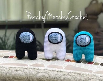 May include: Three crocheted Among Us characters. One is black, one is white, and one is turquoise.