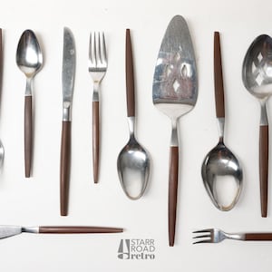 Puede incluir: Un juego de cubiertos vintage con mangos de madera marrón. El juego incluye un tenedor, un cuchillo, una cuchara, una cuchara para servir y un cuchillo para pastel.