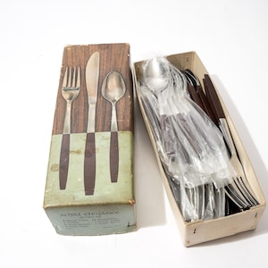 May include: A Royal Elegance 50-piece flatware set featuring stainless steel utensils with dark brown handles. The set includes forks, knives, and spoons, with some pieces individually wrapped in clear plastic inside a rectangular cardboard box.