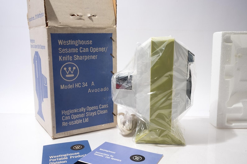 May include: A vintage Westinghouse Sesame Can Opener/Knife Sharpener, model HC 34 A, in its original box. The box is blue and white, with product information and the word "Avocado" printed on it. The can opener is avocado green and white, wrapped in plastic.