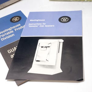 May include: Two vintage Westinghouse manuals. One is blue and black with the text "Westinghouse Portable Product Division". The other is blue and white with the text "Instructions for 'Sesame' Can Openers". Both feature the Westinghouse logo.