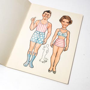May include: Vintage paper dolls featuring a man in a striped tank top and star-patterned shorts, and a woman in a striped skirt and star-patterned bra. The illustrations are in color and are on a cream-colored paper.