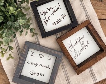 May include: Three square wooden frames with distressed finishes in black, dark brown, and gray. Each frame contains a white insert with handwritten black text: You've got this! Ms. Vec, Thank you Dear Lord!, and I love you very much Gram.
