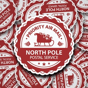 May include: Red and white circular stickers with the text "Priority Air Mail" and "North Pole Postal Service". A white silhouette of a sleigh with presents is in the centre of the sticker.