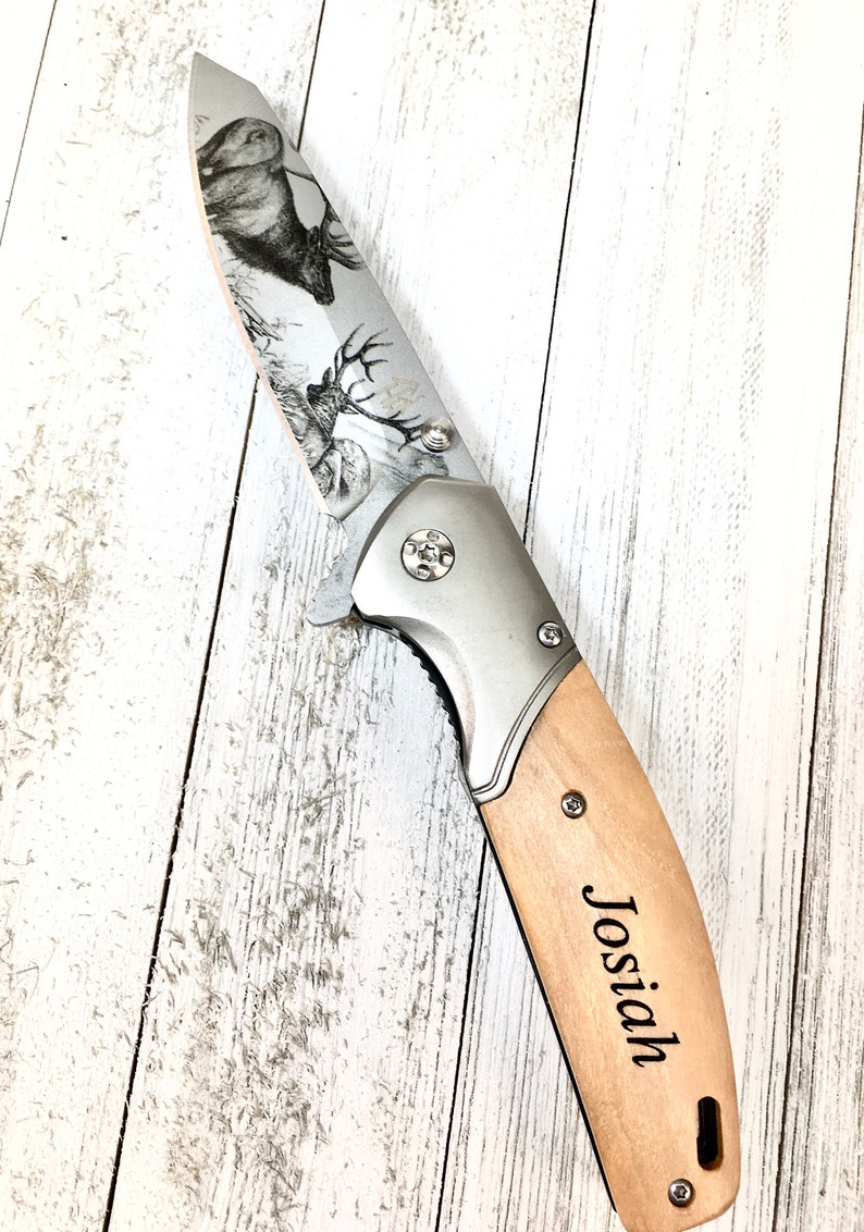 Op de afbeelding: Een zilveren zakmes met een houten handvat. Het lemmet is gegraveerd met een hert en het handvat is gegraveerd met de naam "Josiah".