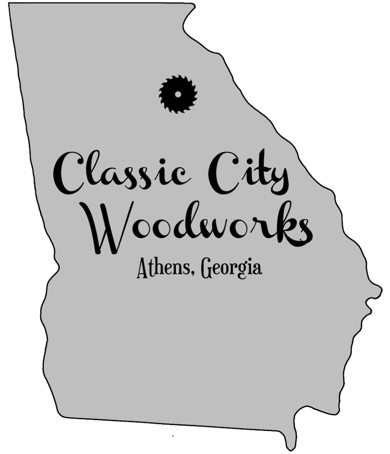 May include: A gray outline of the state of Georgia with the text "Classic City Woodworks" and "Athens, Georgia" below. A black saw blade icon is in the upper center of the image.