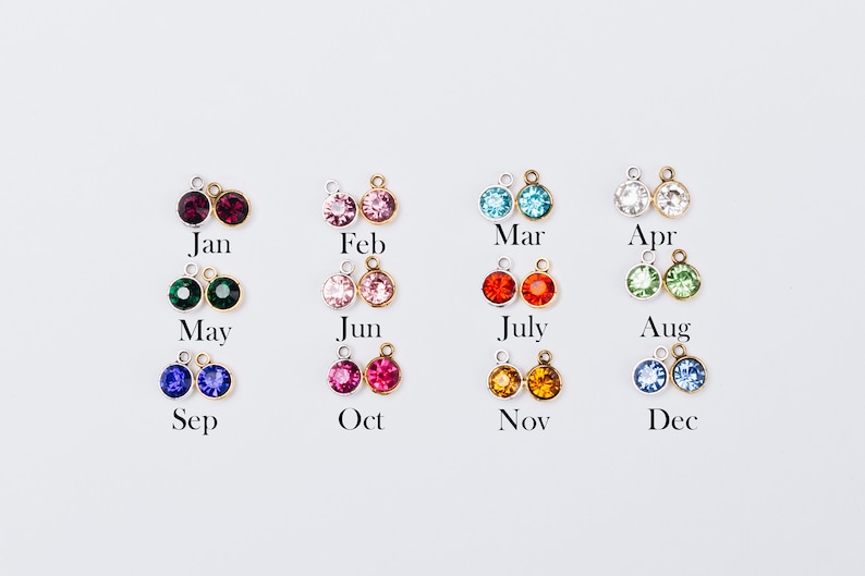 May include: Twelve pairs of small, round, crystal charms in various colors, each charm is attached to a silver loop. The charms are labeled with the months of the year: January, February, March, April, May, June, July, August, September, October, November, and December.