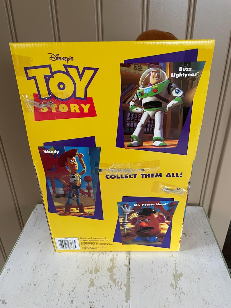 May include: Yellow Disney Toy Story box featuring Woody, Buzz Lightyear, and Mr. Potato Head. The box has the words "Toy Story" in red and blue. The box also says "Collect Them All!"
